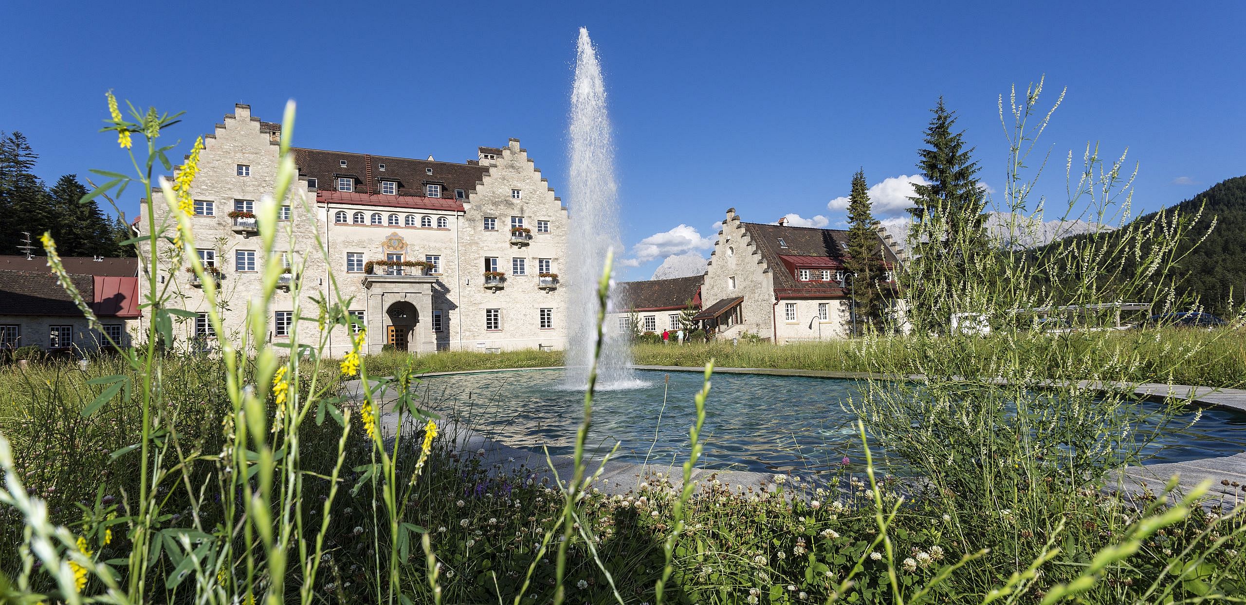 Blick auf die Wasserfontäne und das Anwesen