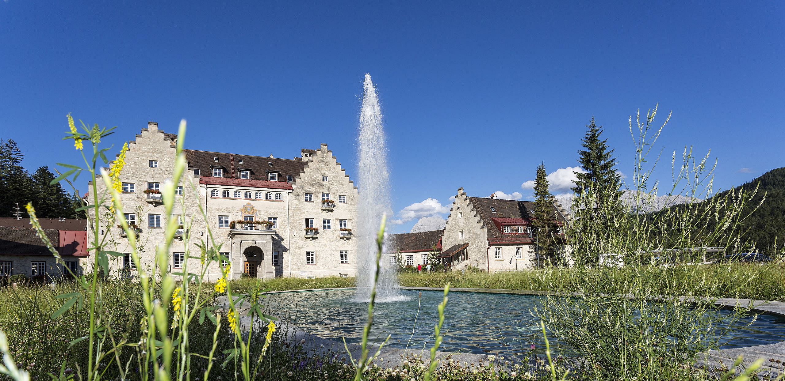 Blick auf die Wasserfontäne und das Anwesen